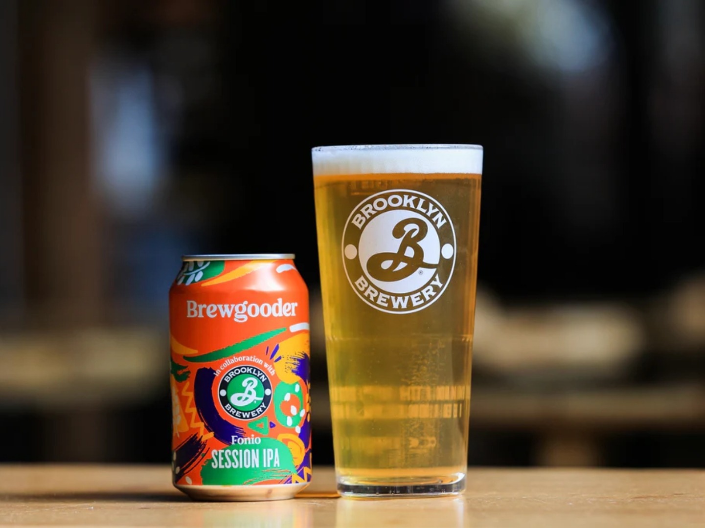 A can of Brewgooder fonio beer is displayed (left) next to a glass of the beer (right).