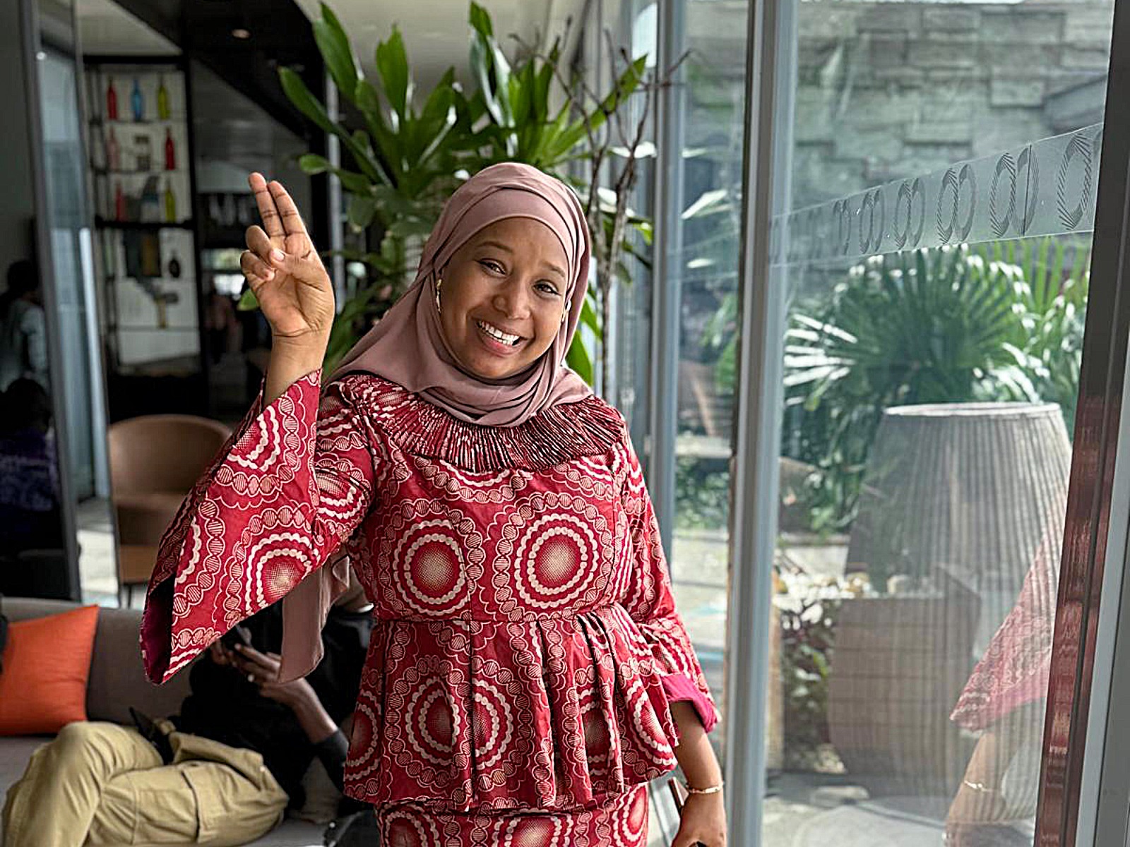 A Guinean woman gives the peace sign while posing for a photo.