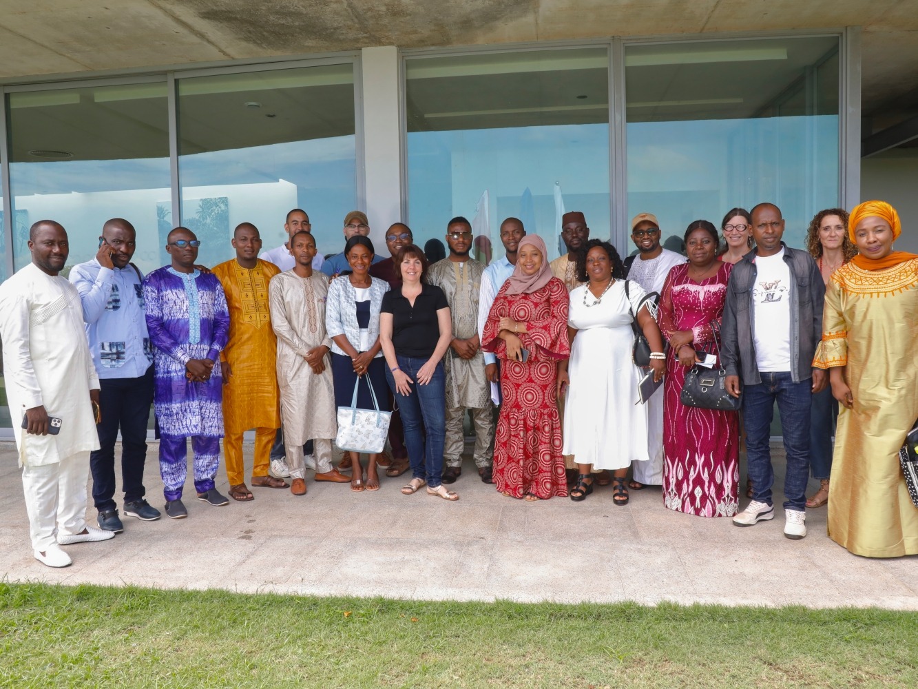 A group of people pose in front of a building for a photo at a meeting in Guinea