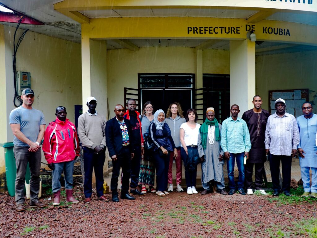 A group of men and women pose for a photo in front of a government building