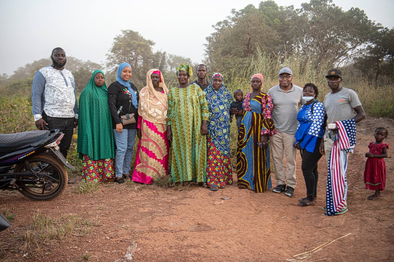 A group of men, women and children stand together to pose for a photo